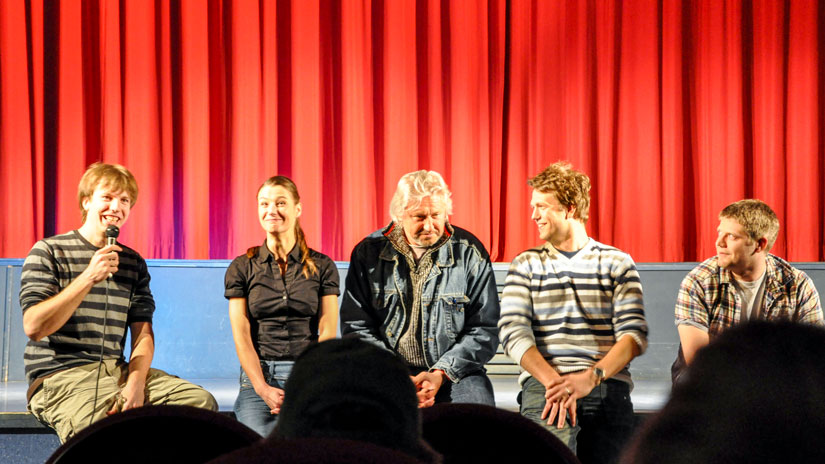 Regisseur Florian Thomi zusammen mit den Hauptdarstellern auf einer Bühne im Anschluss zur Premiere des Kurzfilms Studium-Deluxe