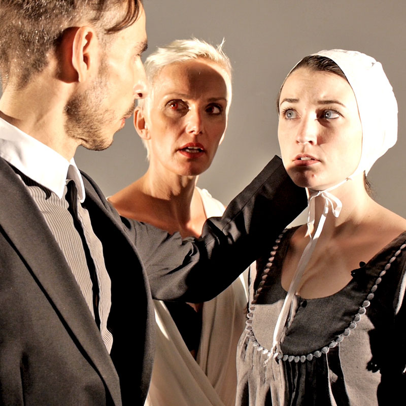 Standbild aus der Theater Trailer Produktion: Zwei Frauen und ein Mann stehen dicht beieinander - sie blicken sich gegenseitig an.